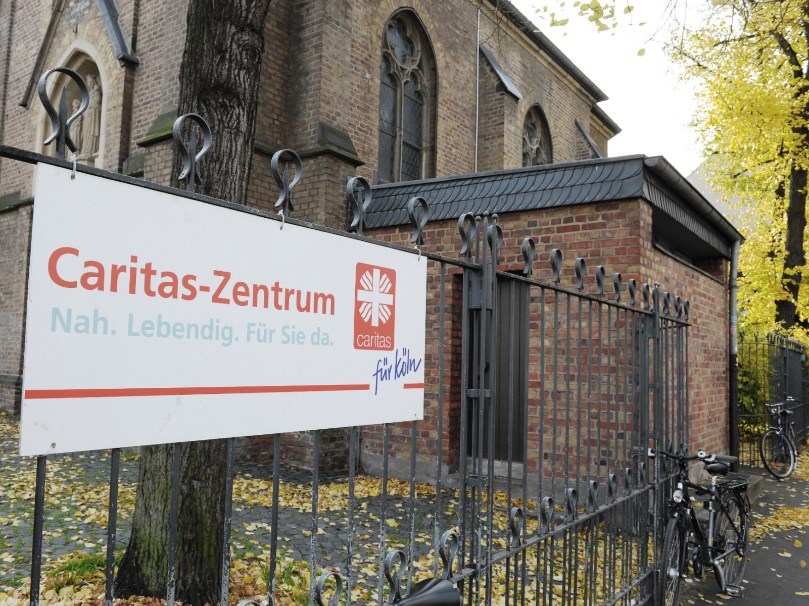 Das Bild zeigt einen Banner auf dem Caritas-Zentrum steht vor einer Kirche